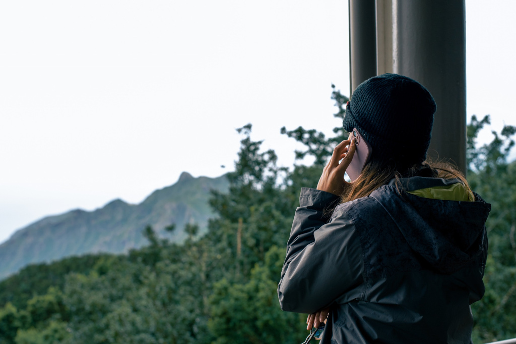 Personne regardant montagnes et forêt à Tenerife, portant un bonnet noir.