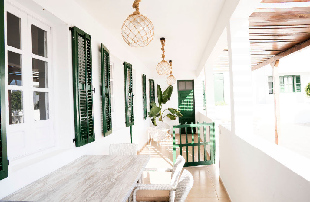 Terrasse avec table en bois, chaises et volets verts à Tenerife.