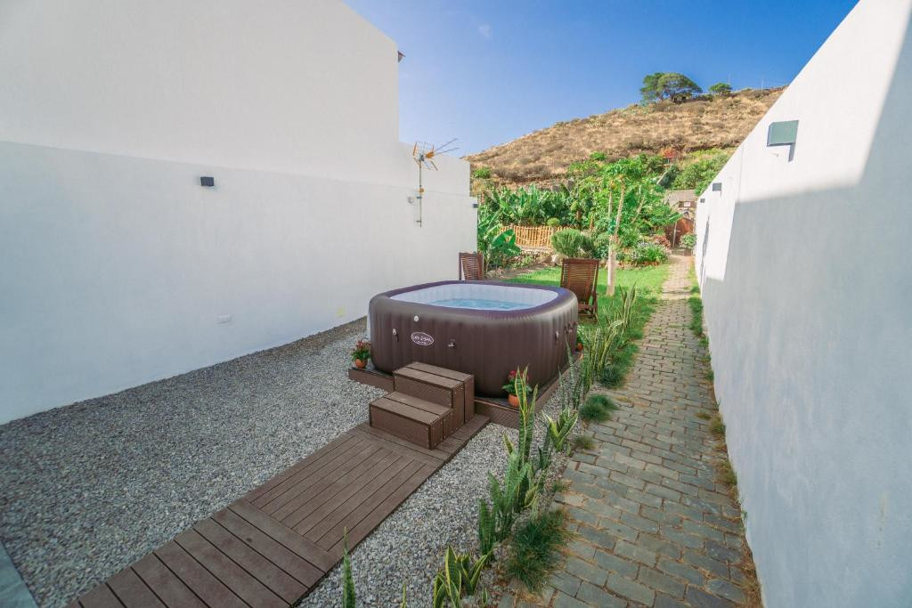 Jacuzzi extérieur dans une cour entourée de murs blancs à Tenerife.