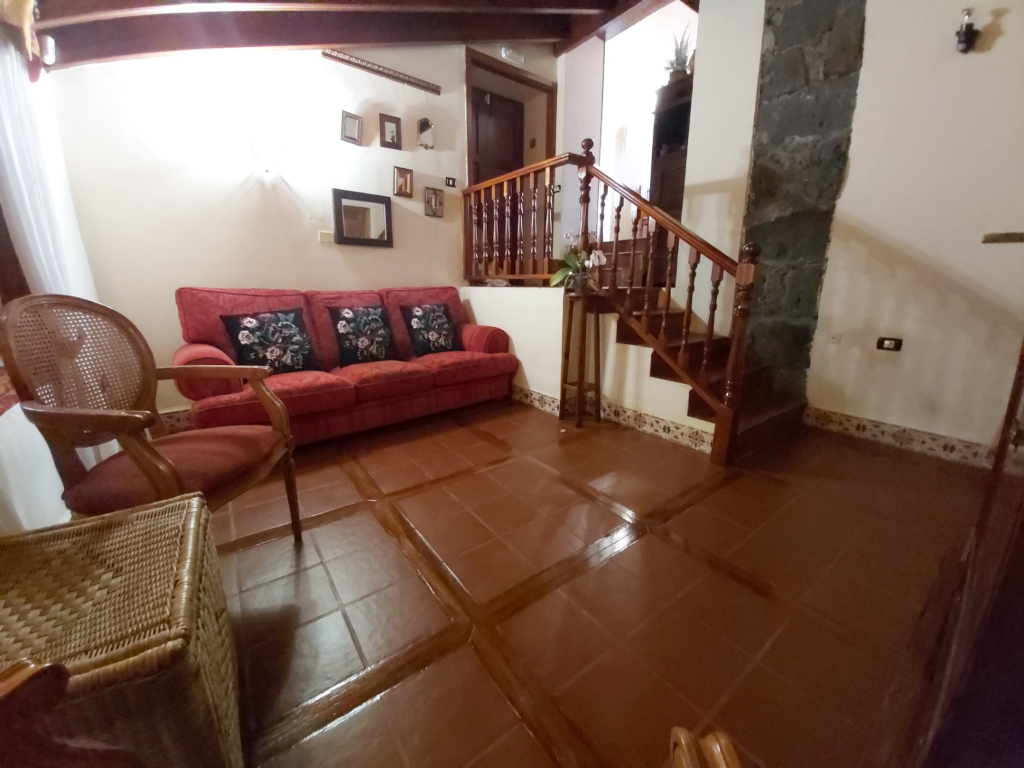 Salon confortable avec canapé rouge et escalier en bois à Tenerife.