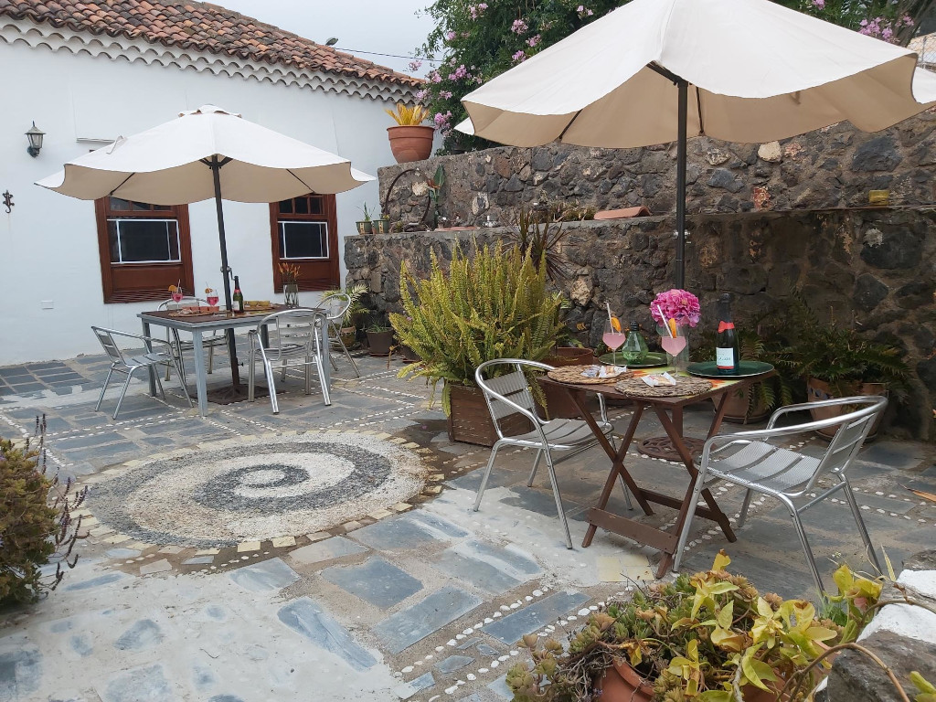 Terrasse à Tenerife avec tables, chaises et parasols sur sol pavé.