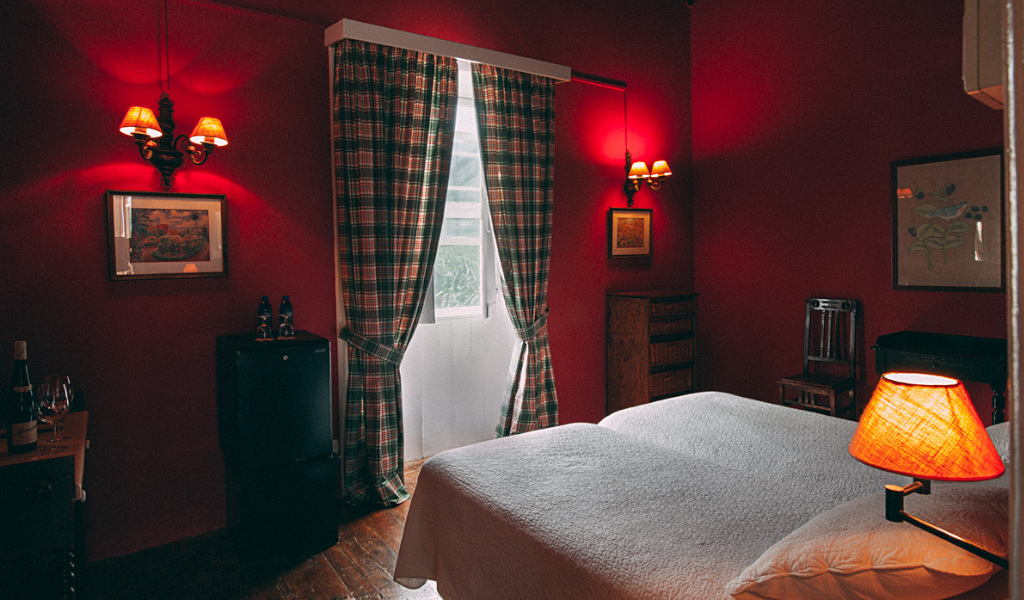 Chambre d'hôtel à Tenerife avec lits jumeaux, lampes et rideaux à carreaux.