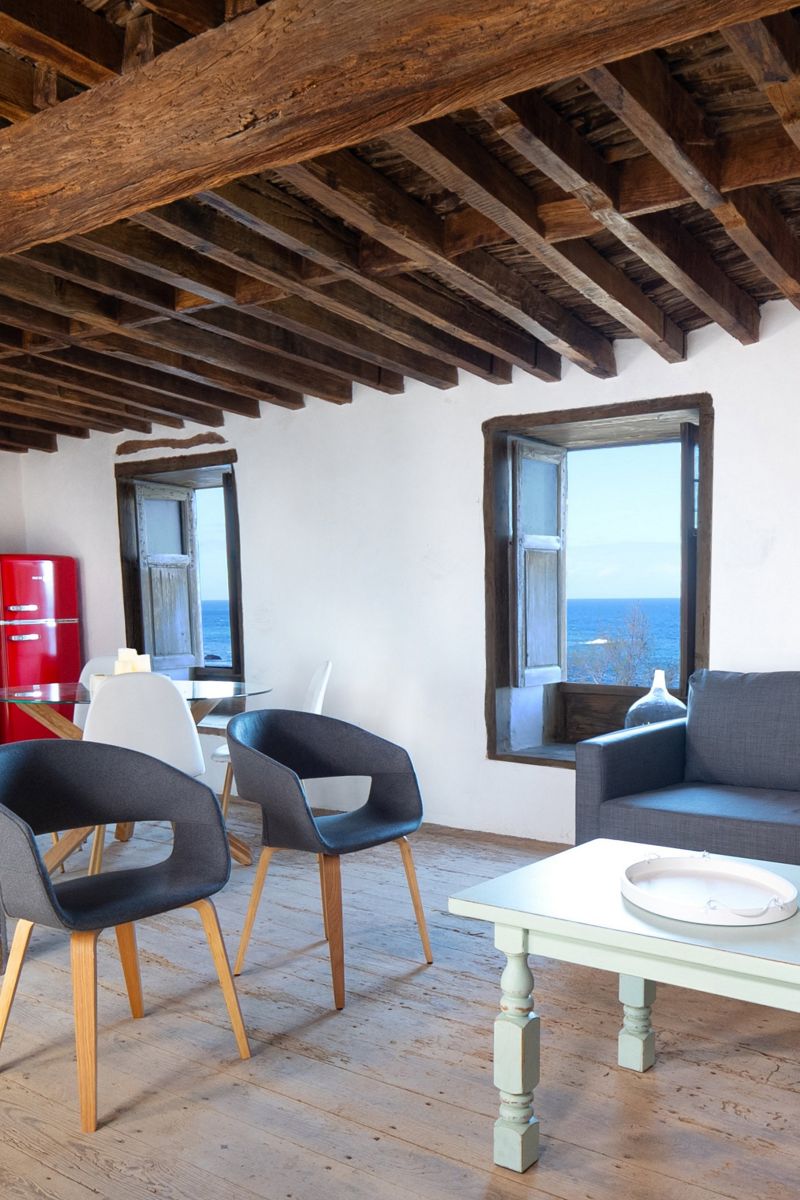 Salon lumineux avec vue sur mer à Tenerife, meubles modernes et plafond en bois.