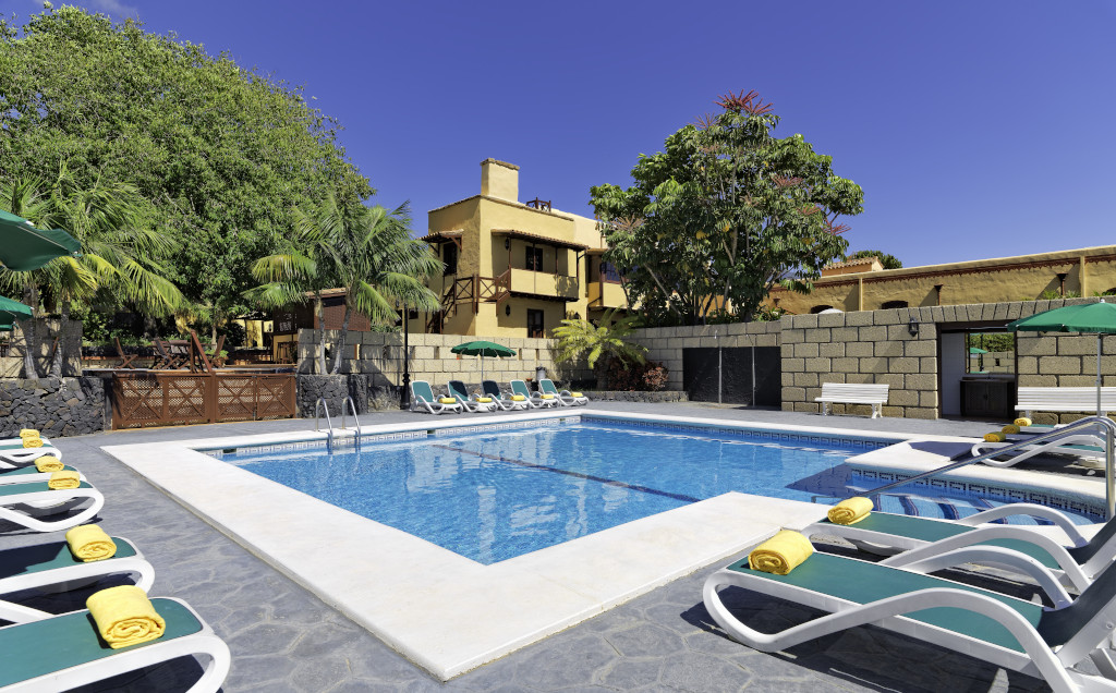 Piscine et chaises longues entourées de palmiers à Tenerife.