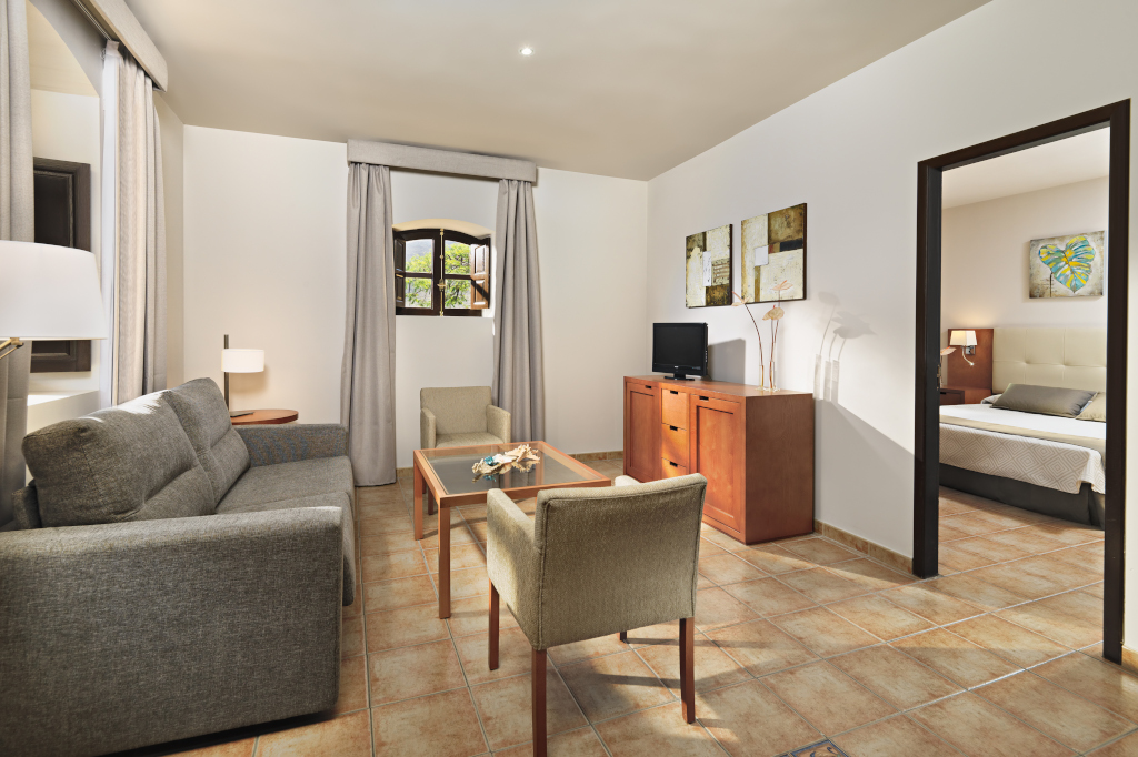 Salon avec canapé, table basse et entrée vers chambre à Tenerife.