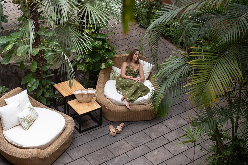 Femme relaxant sur un fauteuil entouré de plantes à Tenerife.
