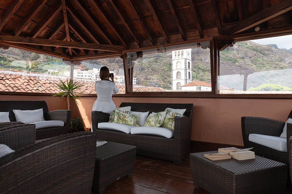 Une femme photographiant l'église depuis une terrasse à Tenerife.