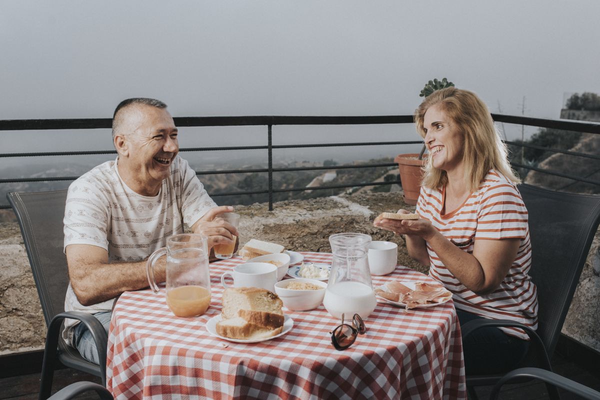 Personnes déjeunant en terrasse à Tenerife avec vue sur la nature.