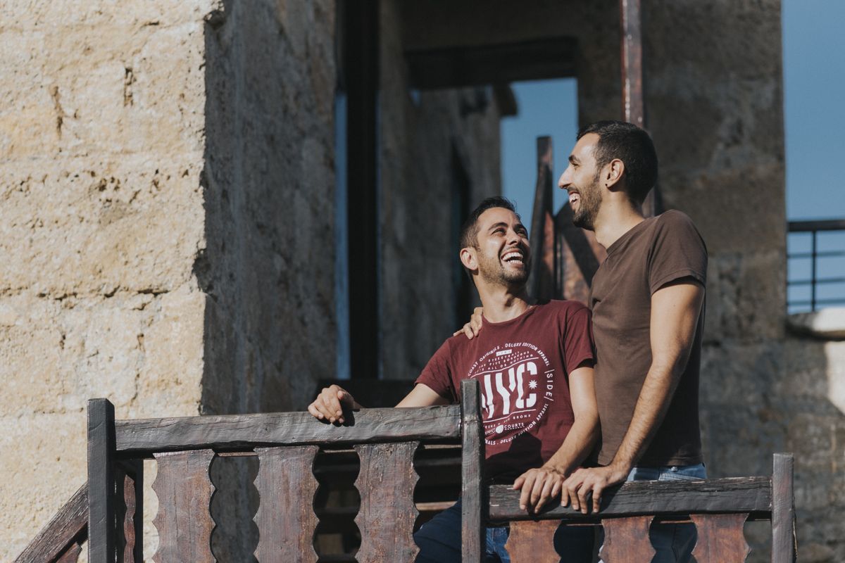 Deux hommes souriants sur un balcon en bois à Tenerife.
