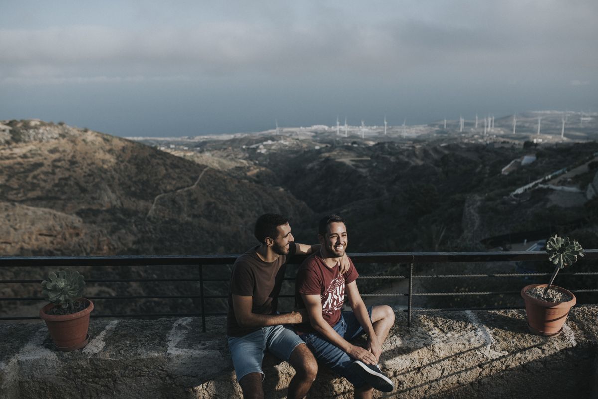 Deux hommes assis sur un muret avec vue sur les montagnes à Tenerife.