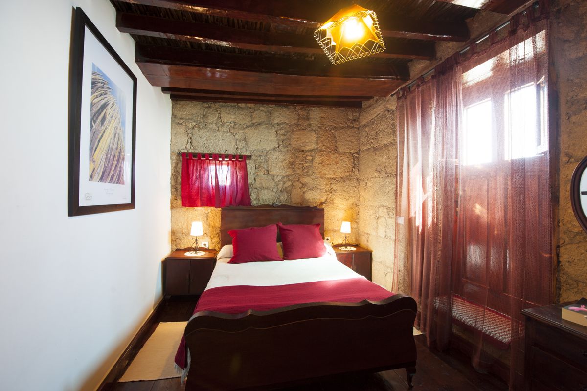 Chambre avec lit double, lampe et rideaux rouges à Tenerife.