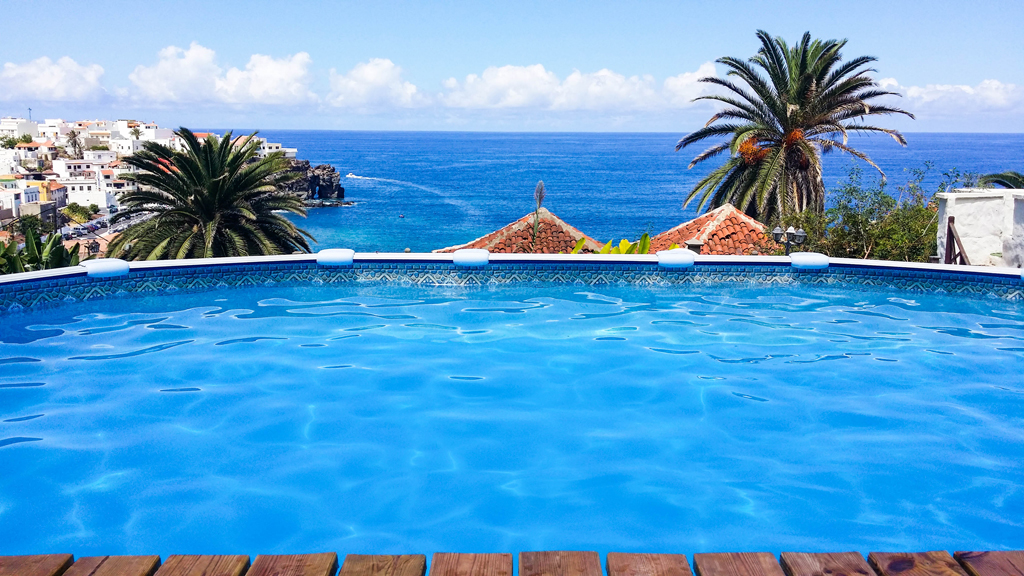 Piscine avec vue sur la mer et palmiers à Tenerife.