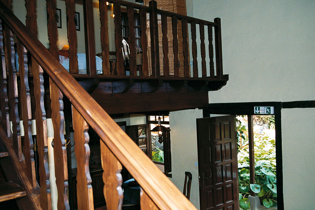 Escalier intérieur en bois avec porte ouverte et plantes visibles à Tenerife.