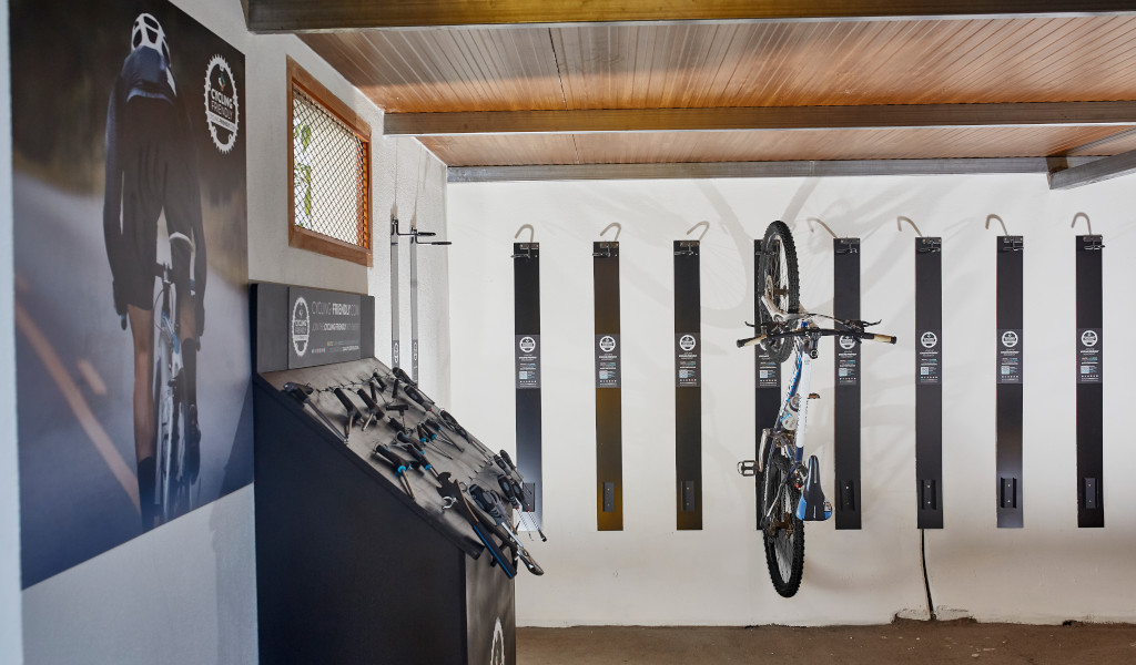 Racks pour vélos avec un vélo suspendu à Tenerife. Image de cycliste au mur.