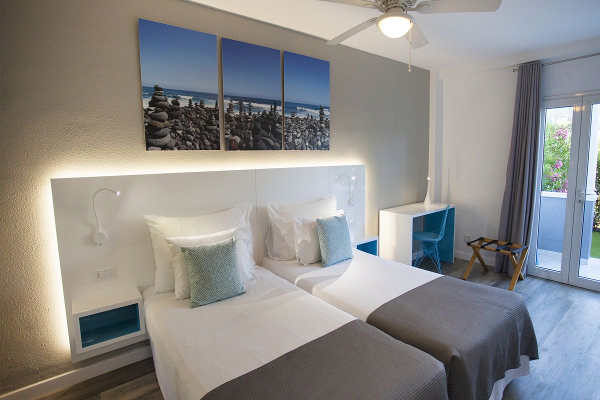 Deux lits simples dans une chambre avec tableau côtier à Tenerife.