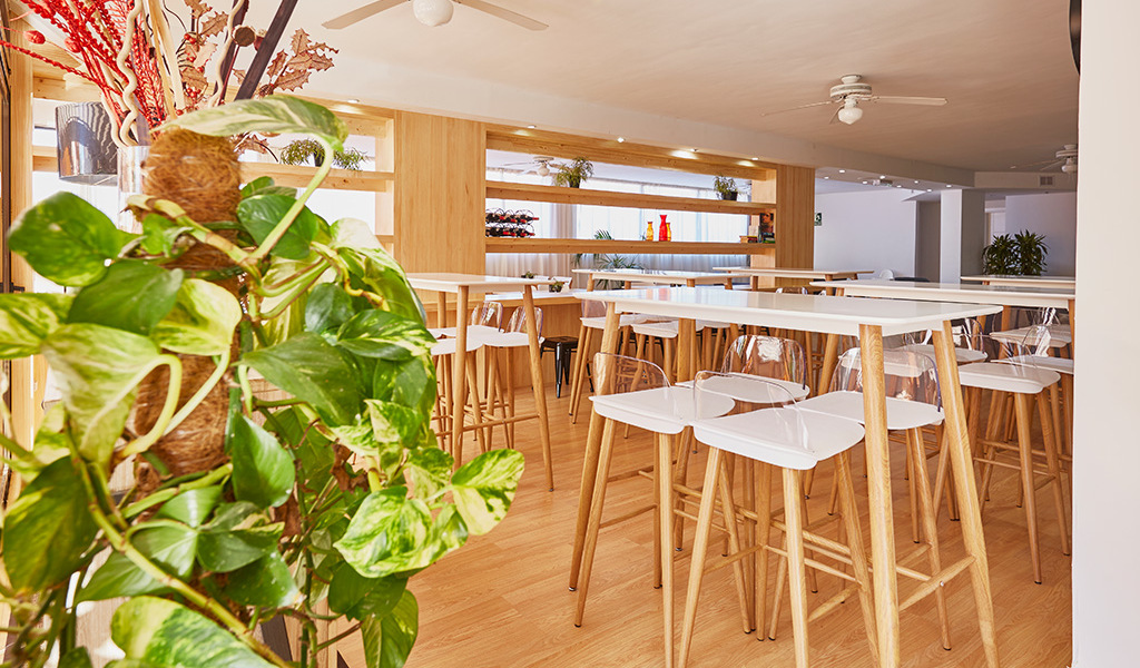 Salle de restaurant moderne à Tenerife avec tables et chaises en bois.