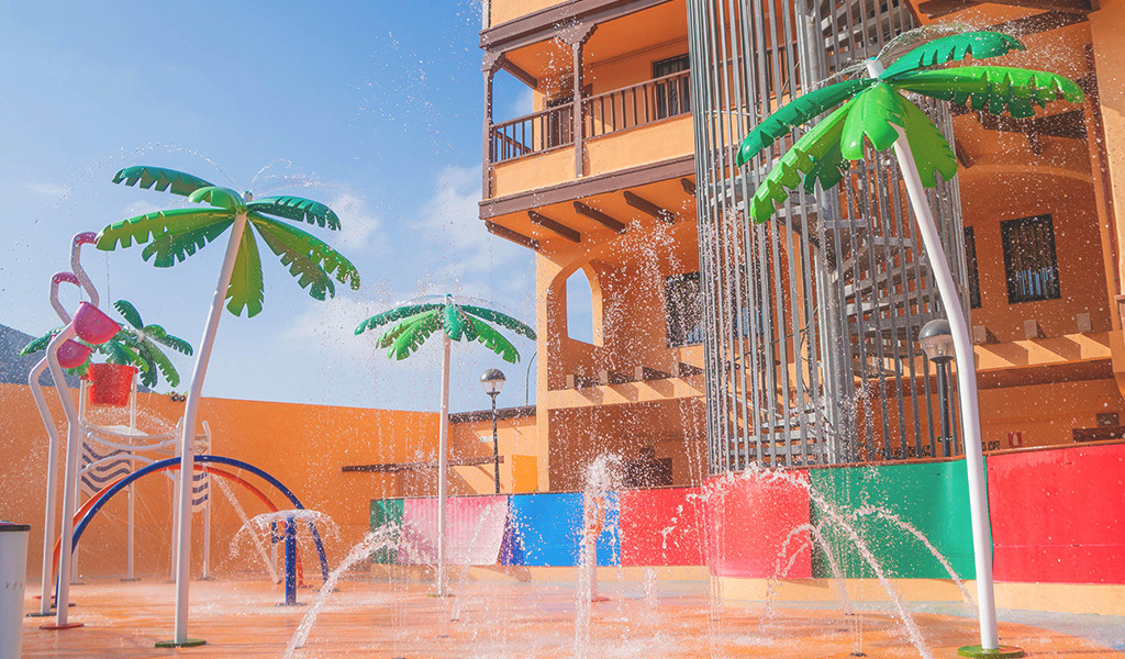 Jets d'eau et palmiers colorés dans un parc aquatique à Tenerife.