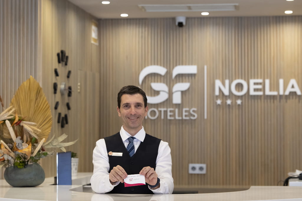 Réceptionniste à l'hôtel Noelia à Tenerife montrant une carte d'invité.