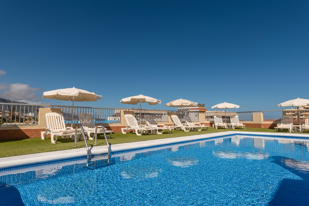 Piscine sur le toit avec parasols et chaises longues à Tenerife.