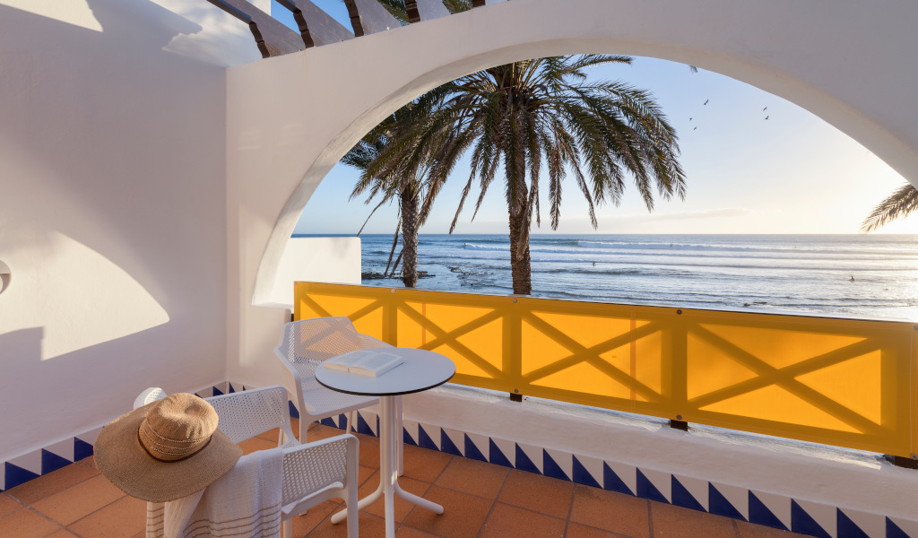 Terrasse avec table, chaise et vue sur la mer et palmiers à Tenerife.