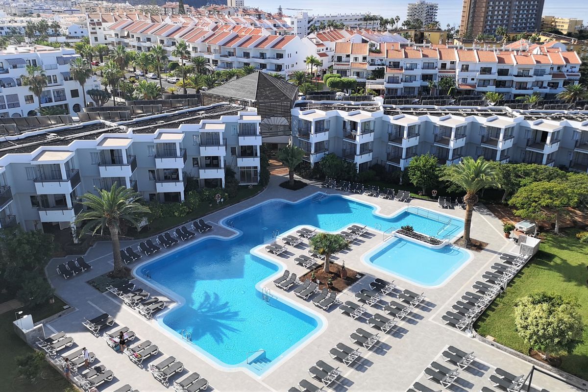 Piscine entourée de chaises longues dans un hôtel à Tenerife.