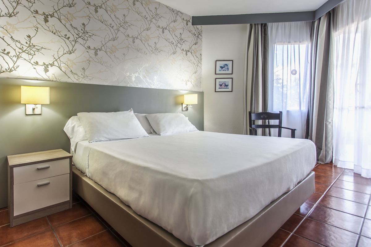 Chambre d'hôtel avec lit double, table de chevet et chaise à Tenerife.