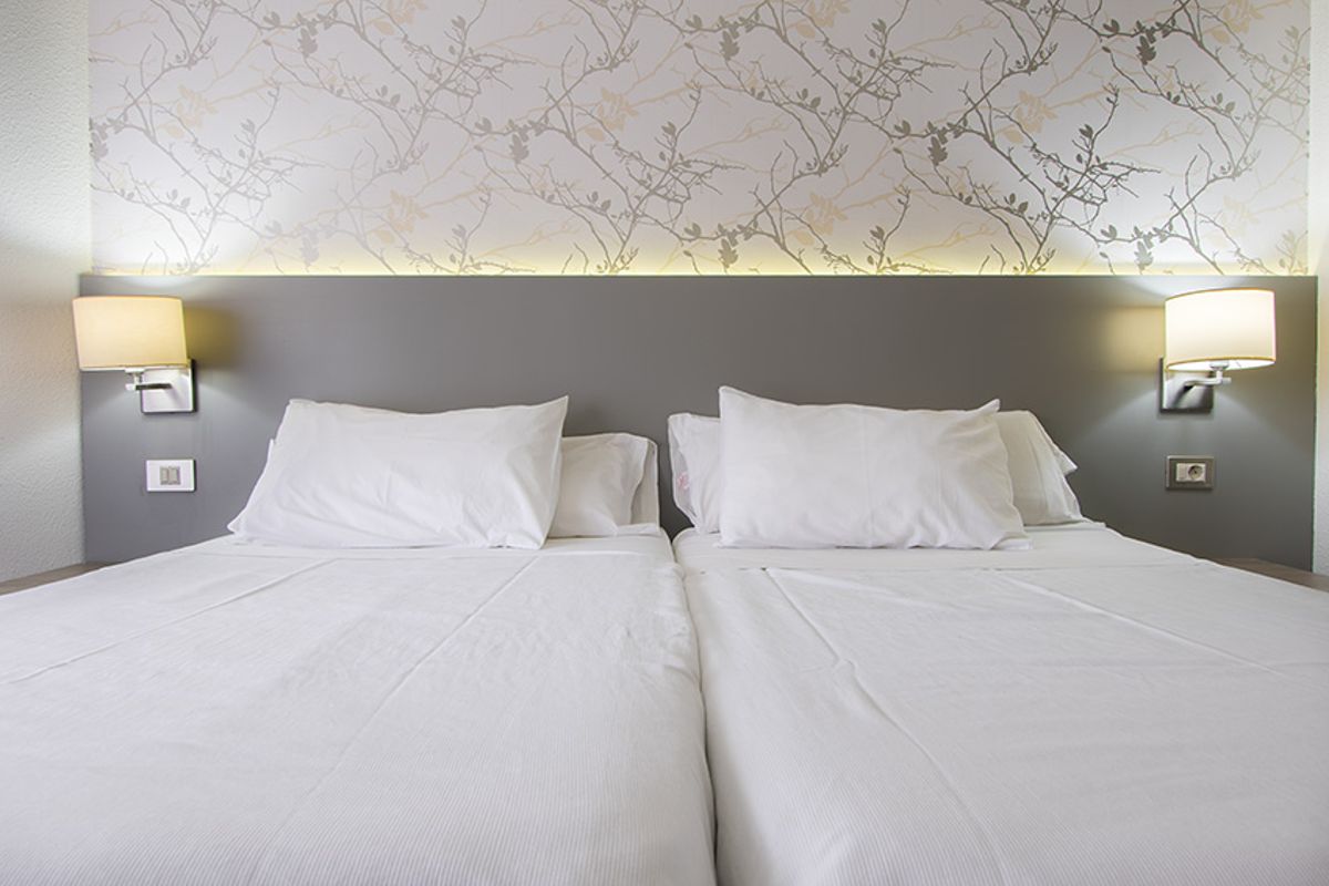 Deux lits simples avec oreillers blancs dans un hôtel à Tenerife.