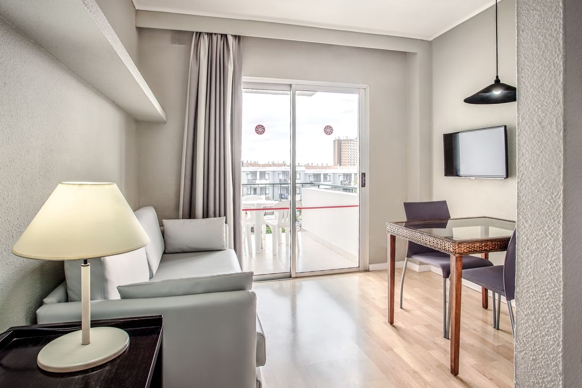 Salon moderne avec canapé, télévision et table à manger, vue sur l'extérieur à Tenerife.
