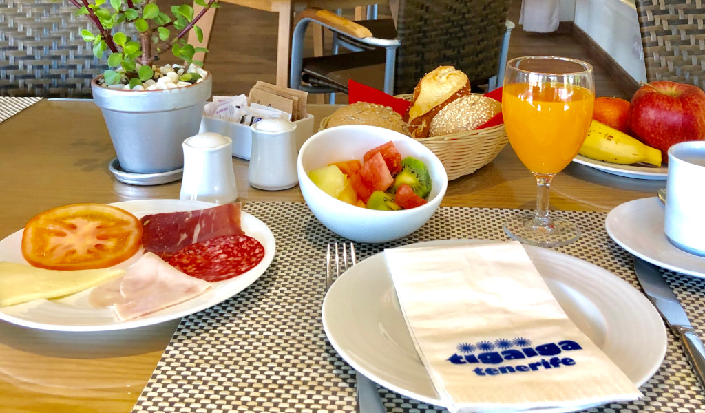 Petit-déjeuner avec charcuterie, fruits, jus d'orange et serviette Taagaga Tenerife”.