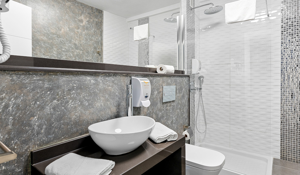 Lavabo moderne avec douche, serviettes et sèche-cheveux à Tenerife.