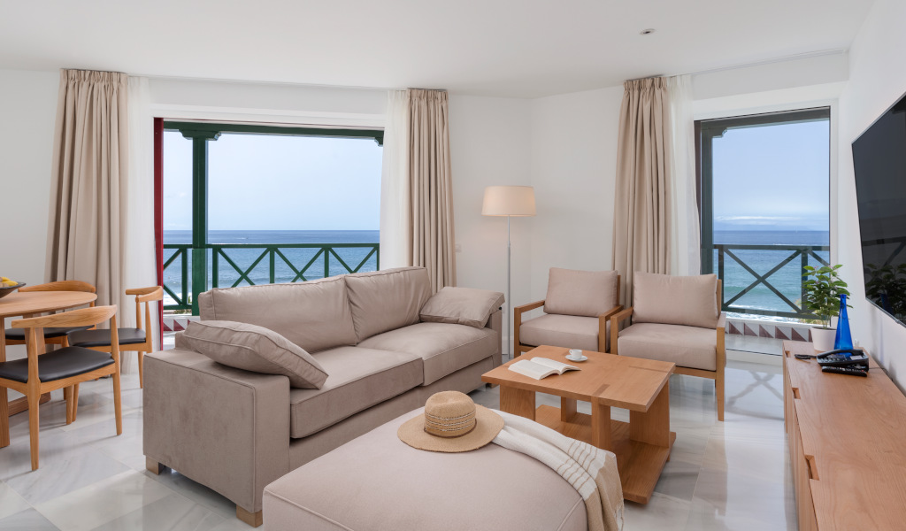 Salon avec vue sur la mer à Tenerife, canapé et table basse en bois.