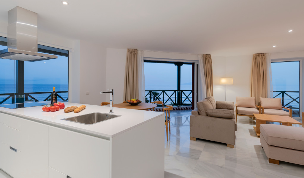 Cuisine et salon avec vue sur l'océan à Tenerife, mobilier moderne et éclairage doux.