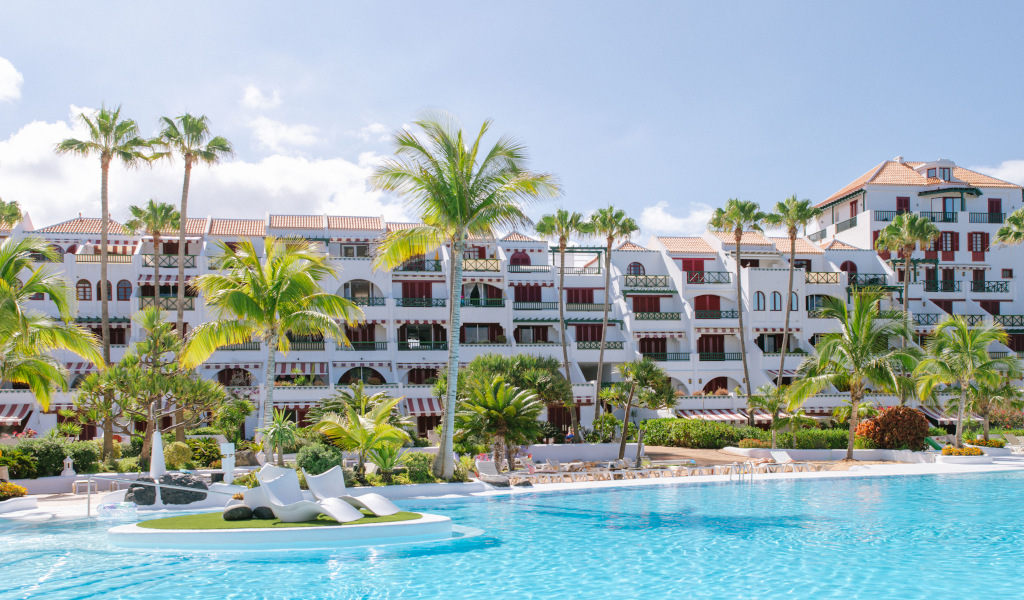 Complexe hôtelier à Costa Adeje, Tenerife, avec piscine et palmiers.
