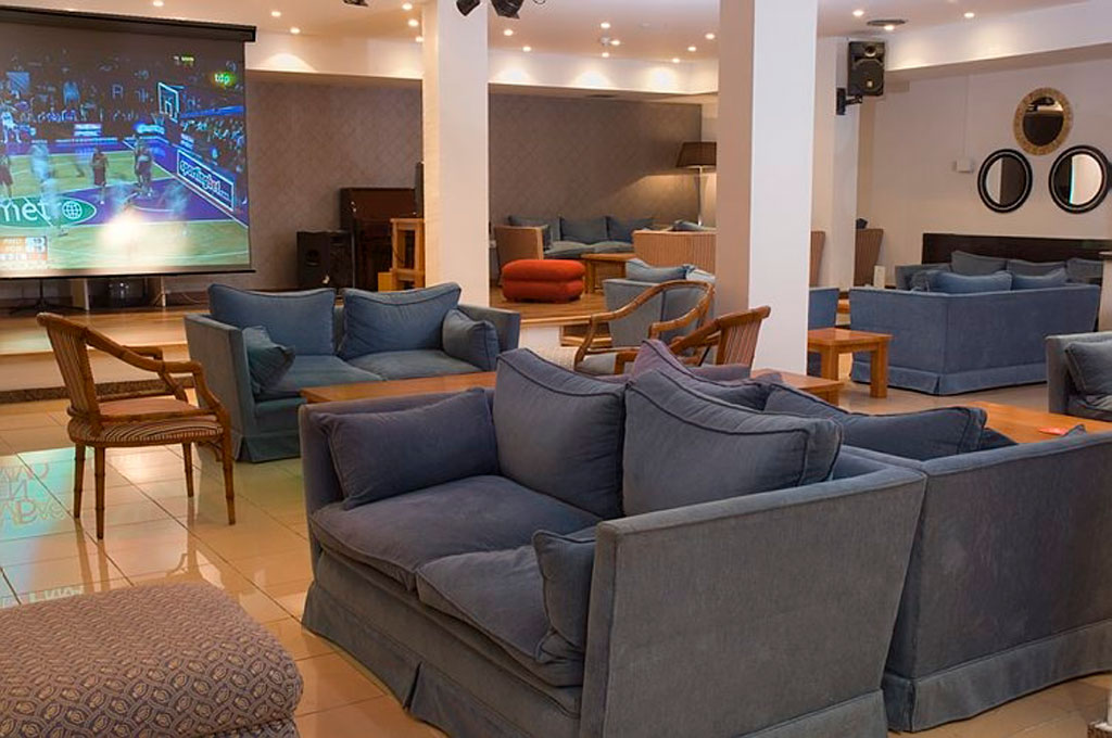 Salle de télévision avec canapés à Tenerife, match de basket à l'écran.