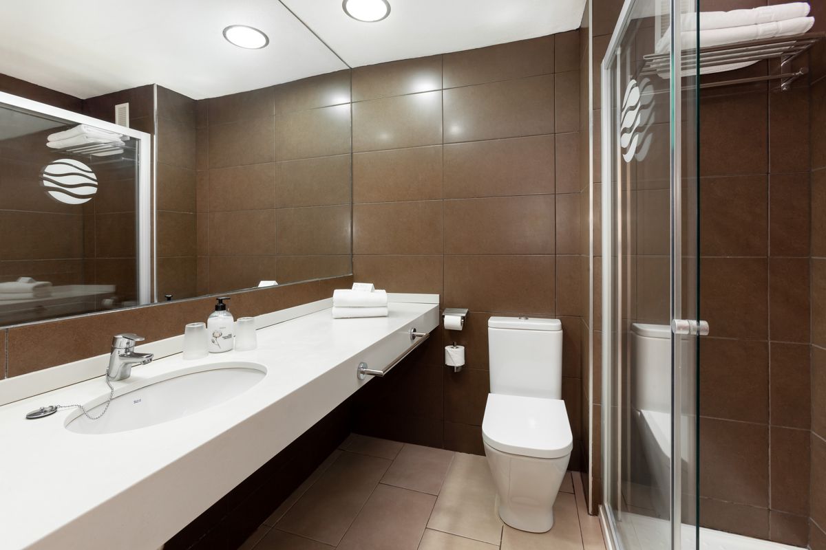 Toilettes modernes avec lavabo, miroir et douche à Tenerife.