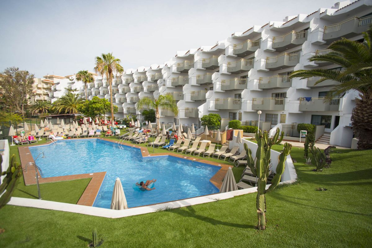 Piscine extérieure entourée de chaises longues et végétation à Tenerife.