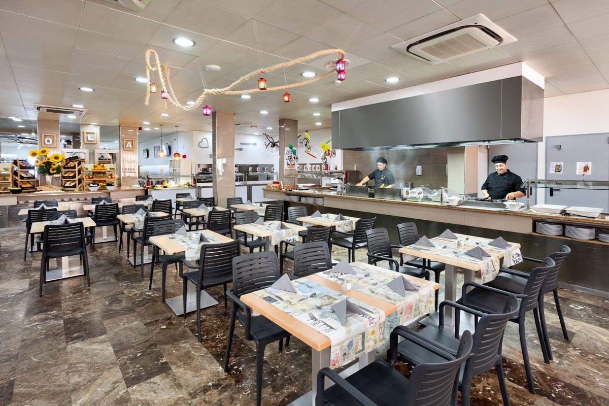 Restaurant avec tables dressées et chefs cuisinant à Tenerife.