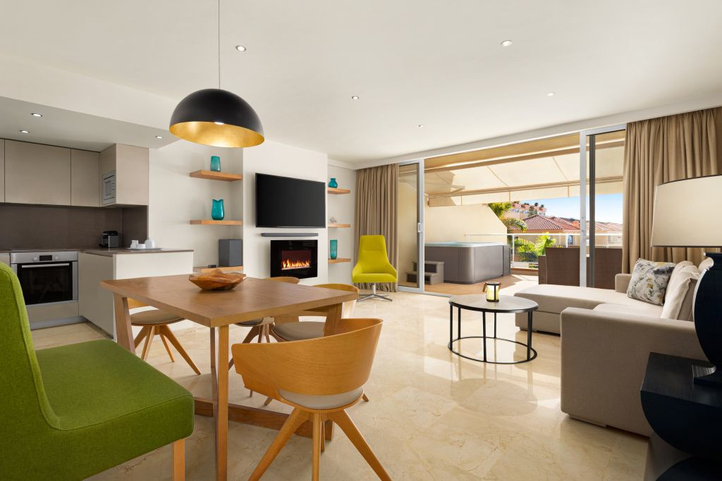 Salon moderne avec cuisine, table, chaises, cheminée et terrasse avec vue à Tenerife.