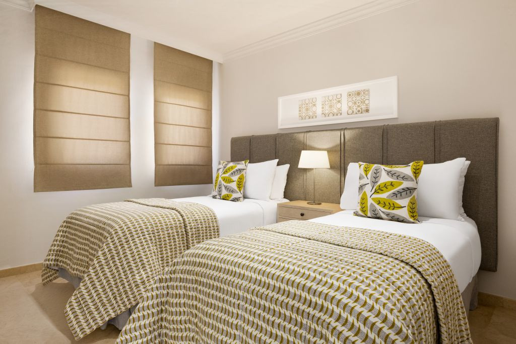 Deux lits simples avec coussins et lampe dans une chambre à Tenerife.