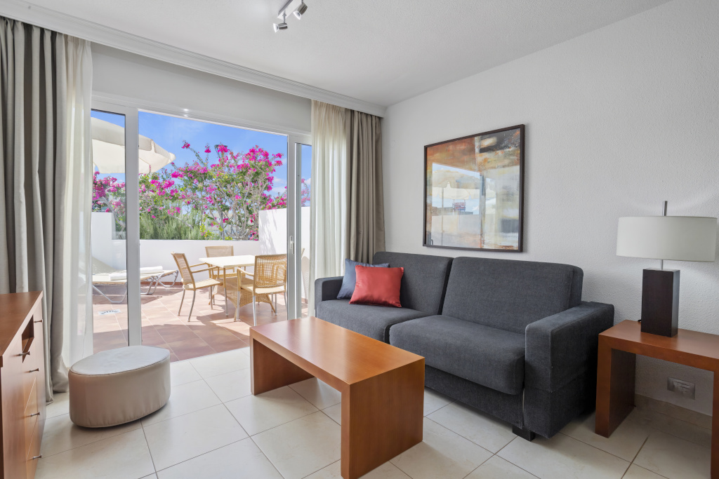 Salon avec canapé et table, vue sur terrasse à Tenerife.