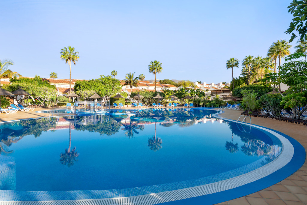 Piscine entourée de palmiers et de chaises longues à Tenerife.