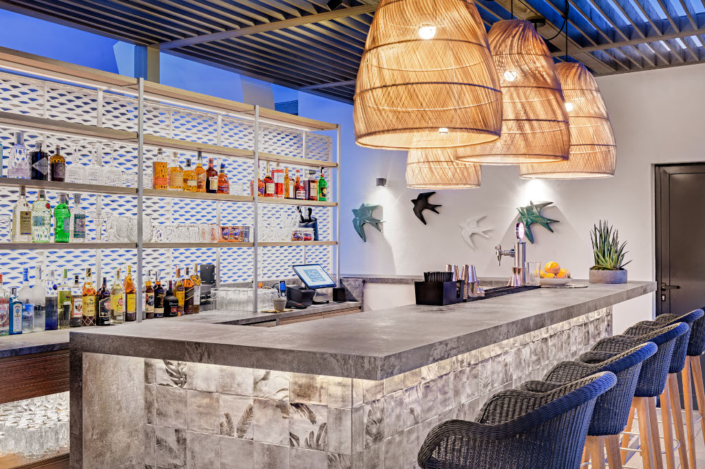 Bar moderne avec étagères de boissons, tabourets en osier et lampes suspendues, Santa Cruz de Tenerife.
