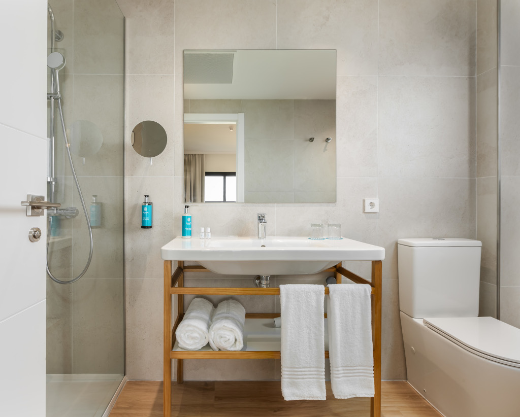 Salle de bain moderne avec douche, lavabo, miroir et toilettes à Tenerife.