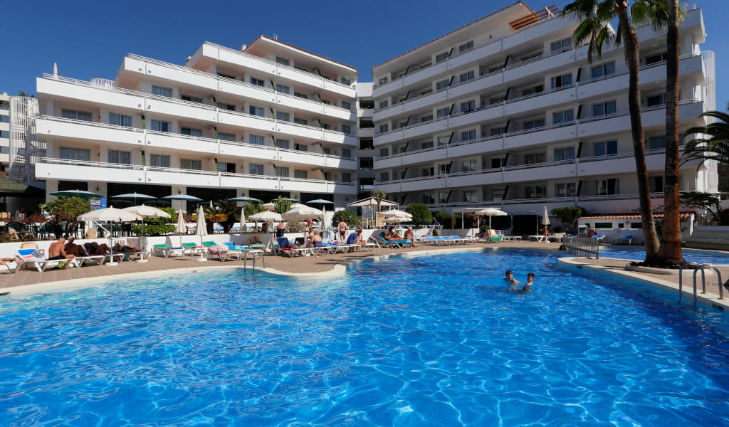 Piscine de l'hôtel à Tenerife avec des personnes se relaxant autour.