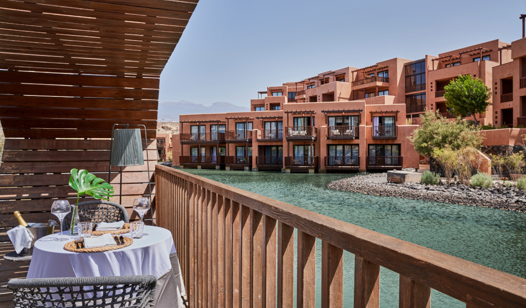 Terrasse avec table et chaises à côté d’un canal d’eau dans un complexe touristique à Tenerife.