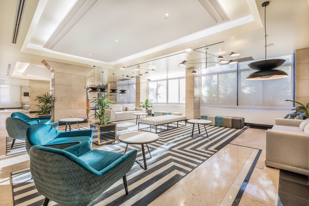 Salon moderne avec chaises bleues, tables et plantes situé à Tenerife.