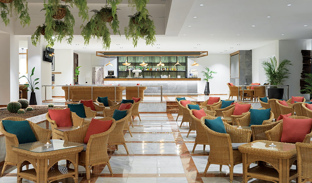 Salon confortable avec fauteuils en osier et bar moderne à Tenerife.