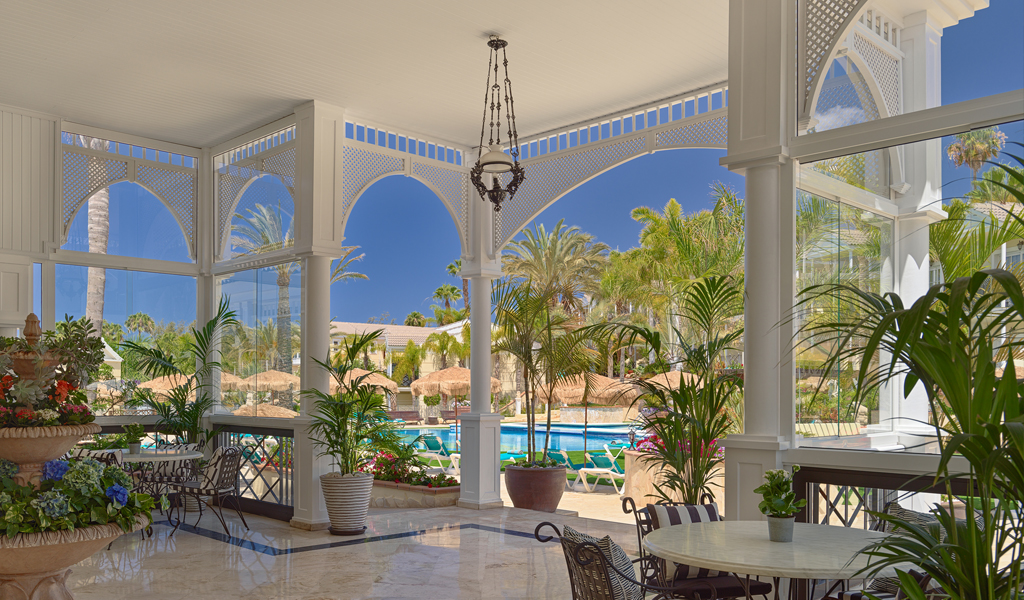 Intérieur d'une véranda avec vue sur une piscine et jardin à Tenerife.