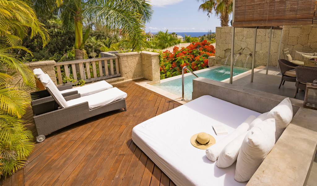 Terrasse à Tenerife avec lits, piscine et vue sur le jardin.