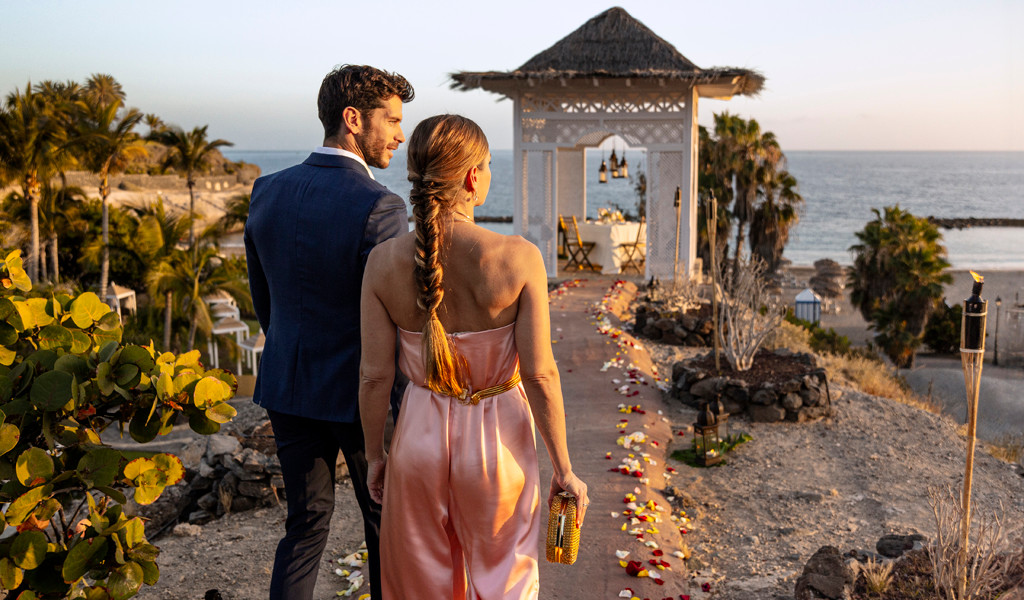 Couple marchant vers un gazebo au bord de l'océan à Tenerife.